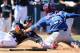 PEORIA, AZ - MARCH 09: Brad Miller #5 of the Seattle Mariners is tagged out at home plate by catcher Robinson Chirinos #61 of the Texas Rangers during the fifth inning of the spring training game at Peoria Stadium on March 9, 2014 in Peoria, Arizona. (P
