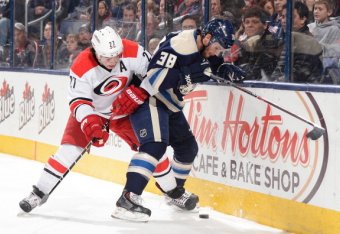 COLUMBUS, OH - JANUARY 10: Boone Jenner #38 of the Columbus Blue Jackets attempts to keep the puck from Justin Faulk #27 of the Carolina Hurricanes during the first period on January 10, 2014 at Nationwide Arena in Columbus, Ohio. (Photo by Jamie Sabau/N