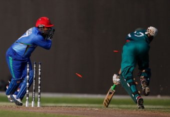 DUBAI, UNITED ARAB EMIRATES - NOVEMBER 24:  Mohammad Shezad of Afghanistan attempts to run out Duncan Allan (R) of Kenya during the ICC World Twenty20 Qualifier between Afghanistan and Kenya at the Sharjah Cricket Stadium on November 24, 2013 in Dubai, Un
