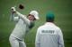 AUGUSTA, GA - APRIL 07: (L-R) Rory McIlroy of Northern Ireland hits a shot as his caddie, J. P. Fitzgerald, looks on during a practice round prior to the start of the 2014 Masters Tournament at Augusta National Golf Club on April 7, 2014 in Augusta, Geor