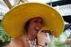 LOUISVILLE, KY - MAY 04: A race fan in a festive hat, smokes a cigar while it rains, prior to the 139th running of the Kentucky Derby at Churchill Downs on May 4, 2013 in Louisville, Kentucky. (Photo by Andy Lyons/Getty Images)