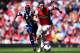LONDON, ENGLAND - MAY 04: Mesut Ozil (R) of Arsenal holds off the challenge of Youssuf Mulumbu (L) of West Bromwich Albion during the Barclays Premier League match between Arsenal and West Bromwich Albion at the Emirates Stadium on May 4, 2014 in London,