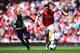 LONDON, ENGLAND - MAY 04: Mesut Ozil (R) of Arsenal holds off the challenge of Youssuf Mulumbu (L) of West Bromwich Albion during the Barclays Premier League match between Arsenal and West Bromwich Albion at the Emirates Stadium on May 4, 2014 in London,