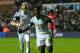 SWANSEA, WALES - FEBRUARY 08: Swansea striker Wilfried Bony (r) celebrates with Chico Flores after scoring the third goal during the Barclays Premier League match between Swansea City and Cardiff City at Liberty Stadium on February 8, 2014 in Swansea, Wa