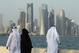 DOHA, QATAR - OCTOBER 24: Men and women wearing traditional Qatari clothing visit the waterfront along the Persian Gulf across from new, budding financial district skyscrapers on October 24, 2011 in Doha, Qatar. Qatar will host the 2022 FIFA World Cup fo