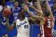 LAWRENCE, KS - FEBRUARY 24: Joel Embiid #21 of the Kansas Jayhawks looks to pass the ball against D.J. Bennett #31 of the Oklahoma Sooners in the second half at Allen Fieldhouse on February 24, 2014 in Lawrence, Kansas. Kansas won 83-75. (Photo by Ed Zu