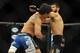 Jul 6, 2014; Las Vegas, NV, USA; Juan Manuel Puig (blue gloves) takes a heavy blow to the face by Adriano Martins (red gloves) during a lightweight fight at Mandalay Bay Events Center. Mandatory Credit: Stephen R. Sylvanie-USA TODAY Sports