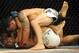 Jul 6, 2014; Las Vegas, NV, USA; Frankie Edgar (red gloves) takes down B.J. Penn (blue gloves) during their featherweight bout at Mandalay Bay Events Center. Mandatory Credit: Stephen R. Sylvanie-USA TODAY Sports