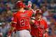 ARLINGTON, TX - AUGUST 15: Kole Calhoun #56 of the Los Angeles Angels celebrates with Mike Trout #27 of the Los Angeles Angels after hitting a three RBI home run against the Texas Rangers in the top of the fifth inning at Globe Life Park in Arlington on