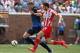 Aug 2, 2014; Minneapolis, MN, USA; Manchester City forward forward Edin Dzeko (10) dribbles the ball past Olympiakos defender Kostas Manolas (24) during the first half at TCF Bank Stadium. Mandatory Credit: Brace Hemmelgarn-USA TODAY Sports