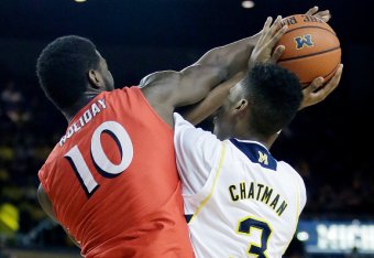 ANN ARBOR, MI - DECEMBER 6:  Daquan Holiday #10 of the New Jersey Institute of Technology Highlanders fouls Kameron Chatman #3 of the Michigan Wolverines while trying to block a shot during the first half at Crisler Arena on December 6, 2014 in Ann Arbor,