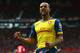 MANCHESTER, ENGLAND - MAY 17: Theo Walcott of Arsenal celebrates as his cross deflects off of Tyler Blackett of Manchester United for an own goal during the Barclays Premier League match between Manchester United and Arsenal at Old Trafford on May 17, 20