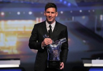 FC Barcelone Argentinian striker Lionel Messi poses with the trophy of Best Men's player in Europe at the end of the UEFA Champions League Group stage draw ceremony, on August 27, 2015 in Monaco. AFP PHOTO / VALERY HACHE        (Photo credit should read V