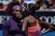 Serena Williams of the US (L) speaks with her sister Venus Williams during their women's doubles match against Sara Errani and Roberta Vinci of Italythe nineth day of the Australian Open tennis tournament in Melbourne on January 22, 2013. AFP PHOTO/PETE