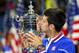 NEW YORK, NY - SEPTEMBER 13: Novak Djokovic of Serbia celebrates with the winner's trophy after defeating Roger Federer of Switzerland during their Men's Singles Final match on Day Fourteen of the 2015 US Open at the USTA Billie Jean King National Tennis