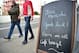 Football fans walk past a chalkboard of a cafe wishing Chelsea's former Portuguese manager Jose Mourinho good luck before the English Premier League football match between Chelsea and Sunderland at Stamford Bridge in London on December 19, 2015. Jose Mour