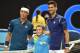 Serbia's Novak Djokovic (R) and Japan's Kei Nishikori (L) pose with a child on court ahead of their men's singles quarter-final match against on day nine of the 2016 Australian Open tennis tournament in Melbourne on January 26, 2016. AFP PHOTO / SAEED KHA