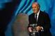 Spain's coach Vicente del Bosque arrives on stage with the trophy before the final draw of the UEFA Euro 2016 football tournament in Paris on December 12, 2015. AFP PHOTO / FRANCK FIFE / AFP / FRANCK FIFE (Photo credit should read FRANCK FIFE/AFP/