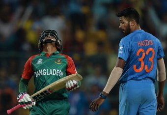 Bangladesh's Mushfiqur Rahim(L) reacts after his dismissal as Indian bowler Hardik Panday(R)looks on during the World T20 cricket tournament match between India and Bangladesh at The Chinnaswamy Stadium in Bangalore on March 23, 2016. / AFP / MANJUNATH KI