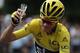 TOPSHOT - Great Britain's Christopher Froome, wearing the overall leader's yellow jersey, is handed a glass of champagne as he rides during the 113 km twenty-first and last stage of the 103rd edition of the Tour de France cycling race on July 24, 2016 bet