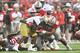COLUMBUS, OH - SEPTEMBER 10: D'Angelo Brewer #4 of the Tulsa Hurricane is wrapped up for no gain by Michael Hill #77 of the Ohio State Buckeyes and Dre'Mont Jones #86 of the Ohio State Buckeyes in the third quarterat Ohio Stadium on September 10, 2016 in