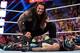 Roman Reigns towers over Rey Mysterio after spearing him at Survivor Series.