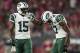 GLENDALE, AZ - OCTOBER 17: Wide receiver Brandon Marshall #15 of the New York Jets helps Charone Peake #17 after Peake was injured during the third quarter of the NFL game against the Arizona Cardinals at the University of Phoenix Stadium on October 17,