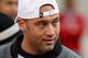 Retired New York Yankee Derek Jeter watches the game from the sideline.