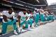 Michael Thomas (third from left) and Dolphins teammates kneel during the national anthem. Dolphins players and ownership soon turned protest into action.