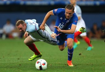 NICE, FRANCE - JUNE 27:  Gylfi Sigurdsson of Iceland tangles with Wayne Rooney of England during the UEFA Euro 2016 Round of 16 match between England and Iceland at Allianz Riviera Stadium on June 27, 2016 in Nice, France.  (Photo by Catherine Ivill - AMA