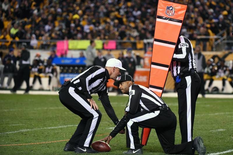 PITTSBURGH, PA - NOVEMBER 13: National Football League officials, referee Clete Blakeman (white hat), field judge Adrian Hill #29 and umpire Carl Paganelli #124, measure for a first down during a game between the Dallas Cowboys and the Pittsburgh Steelers