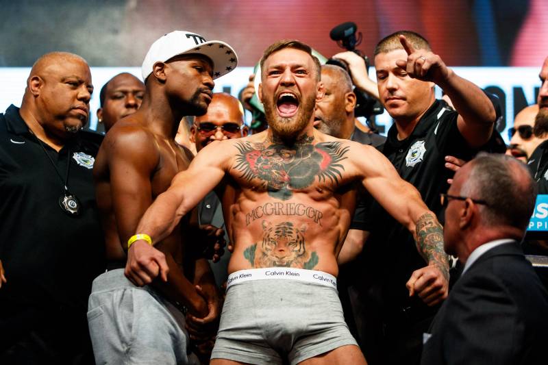 Aug 25, 2017; Las Vegas, NV, USA; Conor McGregor (right) reacts alongside Floyd Mayweather during weigh ins for the upcoming boxing match at T-Mobile Arena. Mandatory Credit: Mark J. Rebilas-USA TODAY Sports