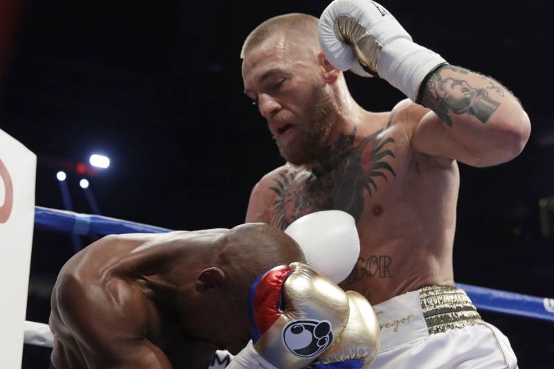 McGregor prepares to deliver a hammer fist blow to the back of Mayweather's head.