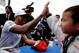 Mercedes' British driver Lewis Hamilton (L) gives a high five to a young boy during the autograph session of the Formula One Japanese Grand Prix at Suzuka circuit on October 5, 2017. / AFP PHOTO / Kiyoshi OTA (Photo credit should read KIYOSHI OTA/A