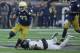 SOUTH BEND, IN - NOVEMBER 04:  Josh Adams #33 of the Notre Dame Fighting Irish breaks a tackle attempt by Cameron Glenn #2 of the Wake Forest Demon Deacons at Notre Dame Stadium on November 4, 2017 in South Bend, Indiana. Notre Dame defeated Wake Forest 4