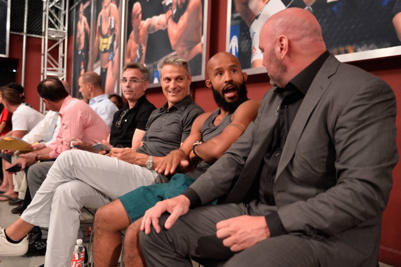 WME CEO Ari Ari Emanuel sitting next to UFC champion Demetrious Johnson and Dana White.