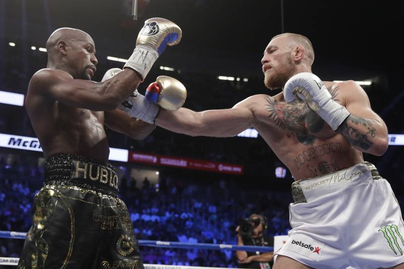 McGregor throws a right hand at Mayweather during their boxing match.