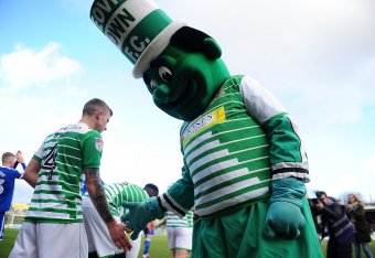 YEOVIL, ENGLAND - JANUARY 20: Jolly Green Giant, the Yeovil Town Mascot high fives Sam Sturridge of Yeovil Town prior to kick off during the Sky Bet League Two match between Yeovil Town and Chesterfield at Huish Park on January 20, 2018 in Yeovil, England