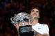 Switzerland's Roger Federer holds the trophy as he celebrates beating Croatia's Marin Cilic in their men's singles final match on day 14 of the Australian Open tennis tournament in Melbourne on January 28, 2018. / AFP PHOTO / SAEED KHAN / -- IMAGE RESTRIC
