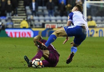 Manchester City's English midfielder Fabian Delph (L) tackle on Wigan Athletic's English midfielder Max Power leads to a red card during the English FA Cup fifth round football match between Wigan Athletic and Manchester City at the DW Stadium in Wigan, n