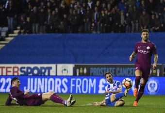 Wigan Athletic's English-born Northern Irish striker Will Grigg (C) scores his team's first goal during the English FA Cup fifth round football match between Wigan Athletic and Manchester City at the DW Stadium in Wigan, northwest England, on February 19,