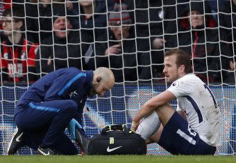 Tottenham Hotspur's English striker Harry Kane (R) receives medical attention after picking up an injury during the English Premier League football match between Bournemouth and Tottenham Hotspur at the Vitality Stadium in Bournemouth, southern England on