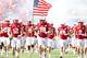 Damian Jackson, with American flag, leads Nebraska onto the field.
