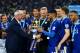   LEICESTER, ENGLAND - MAY 07: Claudio Ranieri Director of Leicester City passes the Premier League trophy to Kasper Schmeichel and Riyad Mahrez While players and teams celebrate the champions of the season after the Barclays Premier League match between Leicester C 