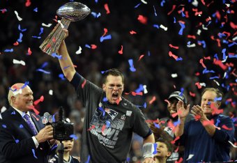 TOPSHOT - Tom Brady #12 of the New England Patriots holds the Vince Lombardi Trophy as Head coach Bill Belichick (R) looks on  after defeating the Atlanta Falcons 34-28 in overtime during Super Bowl 51 at NRG Stadium on February 5, 2017 in Houston, Texas.