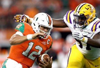 ARLINGTON, TX - SEPTEMBER 02:  Malik Rosier #12 of the Miami Hurricanes runs the ball against Glen Logan #97 of the LSU Tigers in the first quarter during the AdvoCare Classic at AT&T Stadium on September 2, 2018 in Arlington, Texas.  (Photo by Ronald Mar