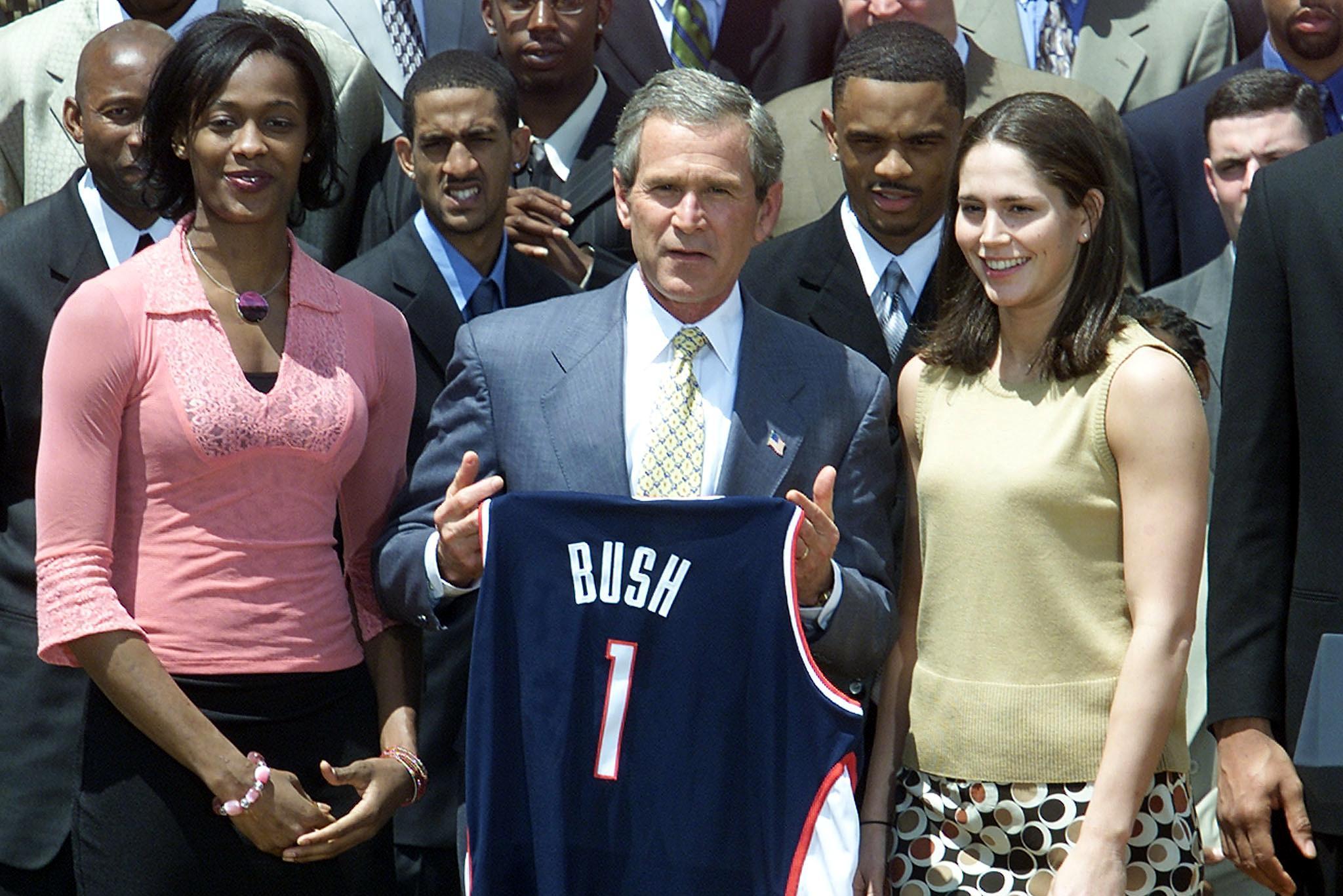 WASHINGTON, :  US President George W. Bush (C) participates in a photo opportunity with NCAA Champions on the South Lawn of The White House in Washington, DC 21 May 2002.  University of Connecticut women's basketball players Sue Bird(L) and Swin Cash gave