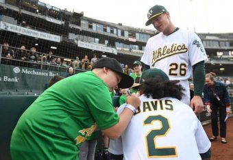 Anthony Slocumb (left) signs Davis' jersey hours before the Oakland slugger hit another of his 48 home runs this season.