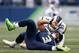 SEATTLE, WA - DECEMBER 17: Quarterback Russell Wilson #3 of the Seattle Seahawks is sacked by defensive tackle Aaron Donald #99 of the Los Angeles Rams in the second quarter at CenturyLink Field on December 17, 2017 in Seattle, Washington. (Photo by Ott