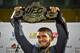 UFC lightweight champion Khabib Nurmagomedov of Russia raises his champions belt upon the arrival in Makhachkala on October 8, 2018. - Nurmagomedov defeated Conor McGregor of Ireland in their UFC lightweight championship bout by way of submission during t